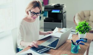 Femme au travail utilisant un ordinateur dans le cadre de la dématérialisation et du développement durable