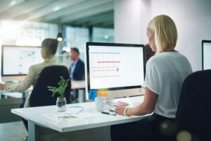 Femme devant un ordinateur pour organiser et protéger les informations de son entreprise